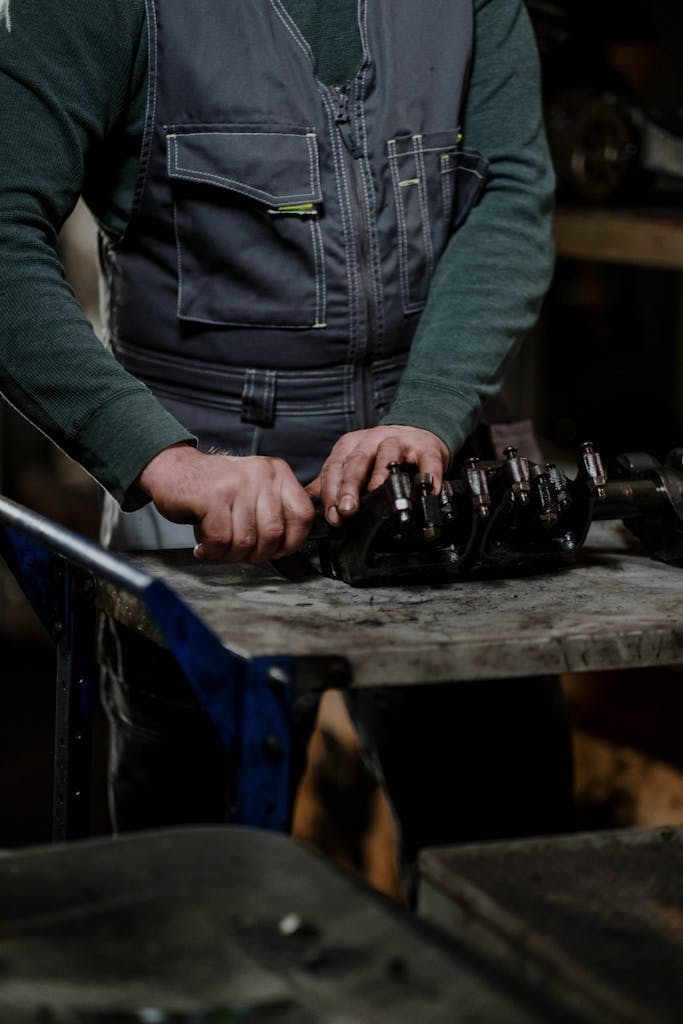 Close Up Of A Male Mechanic Disassembling A Car Engine In A Dimly Lit Workshop. 7568413 683x1024
